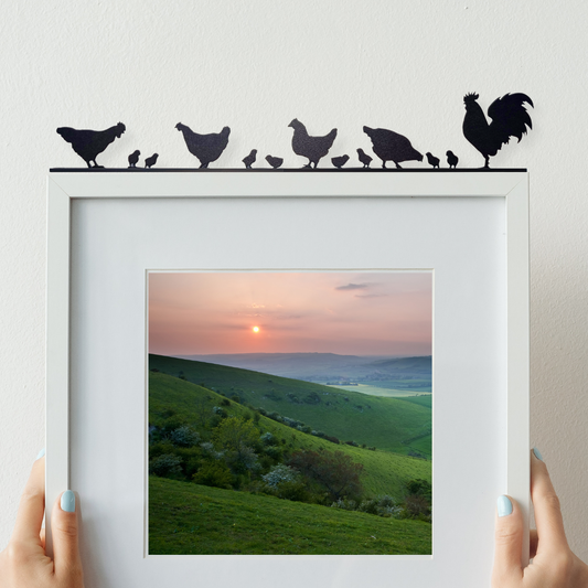 ornament made from recycled plastic depicting cocks, hens and their chicks on top of a picture frame