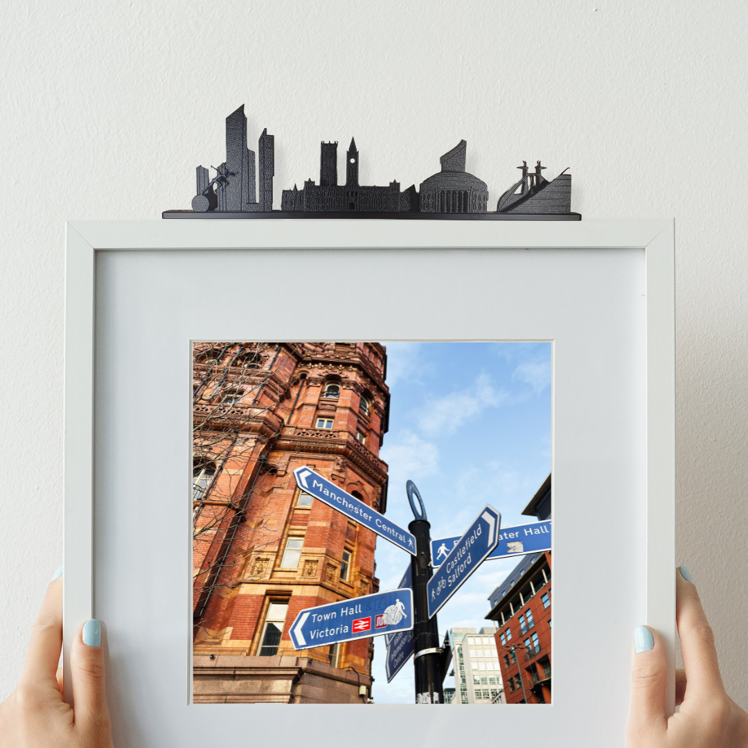 Manchester skyline ornament made from recycled plastic on top of a picture frame